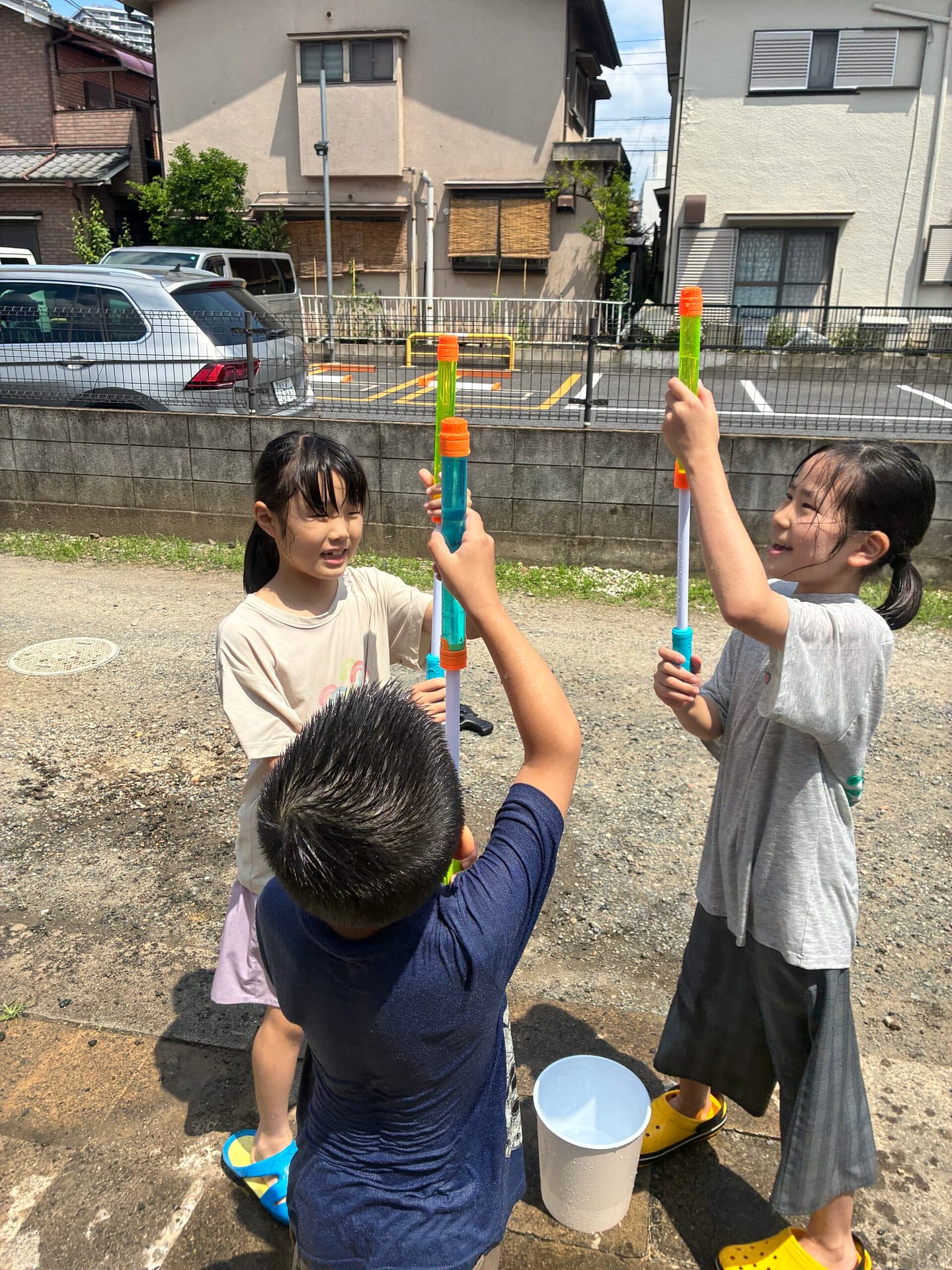 屋外で水を使って遊ぶ子どもたち