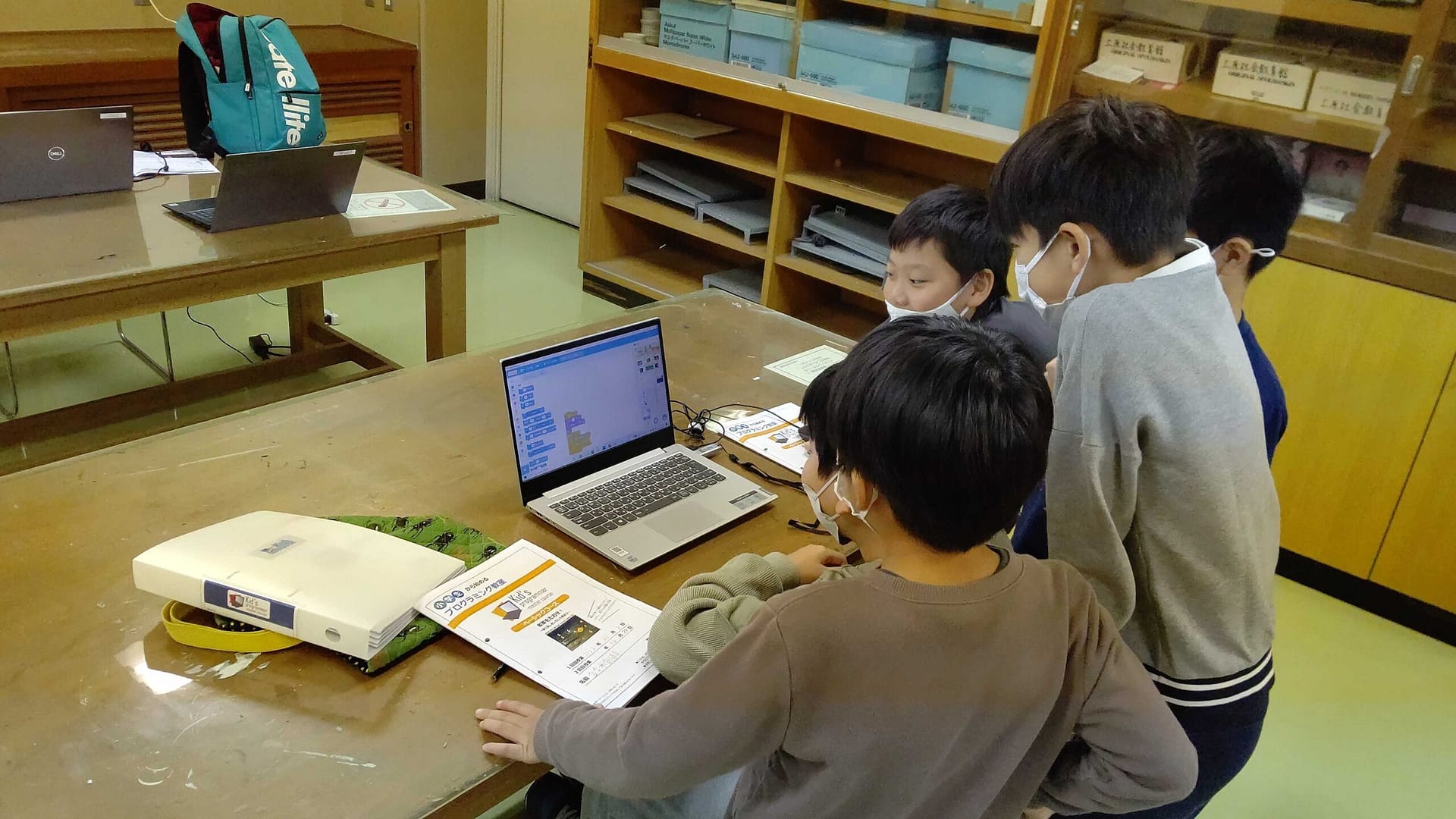 机に並んでノートパソコンに向かう子どもたち