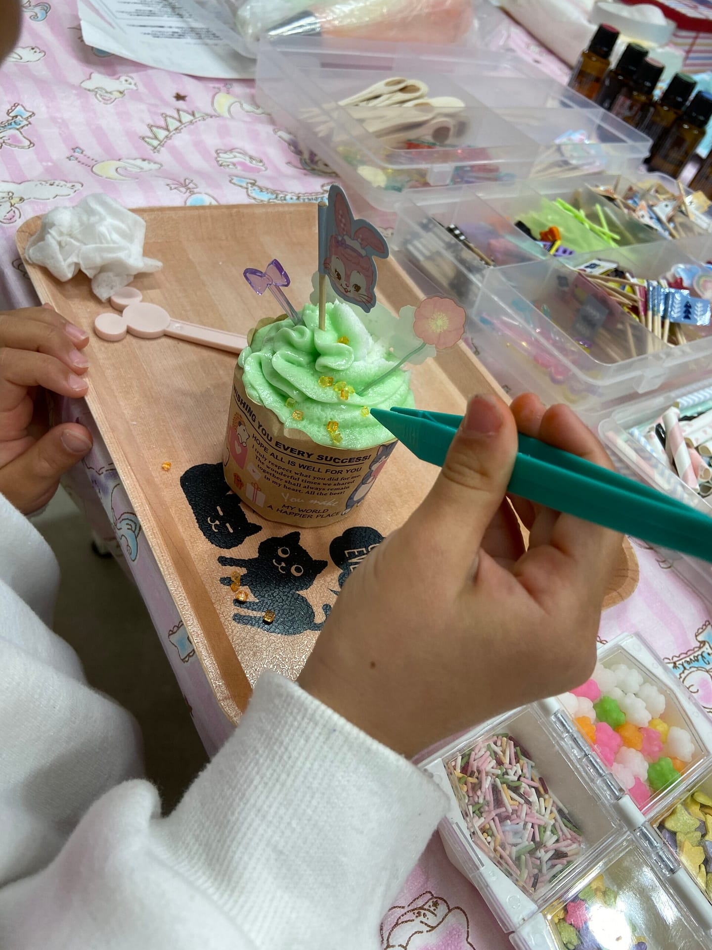 机に向かって小さな部品を組み立てる子どもの手元