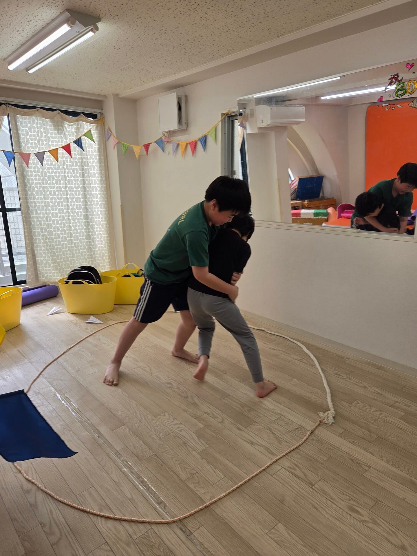 明るい室内で体を動かして過ごす子どもたち