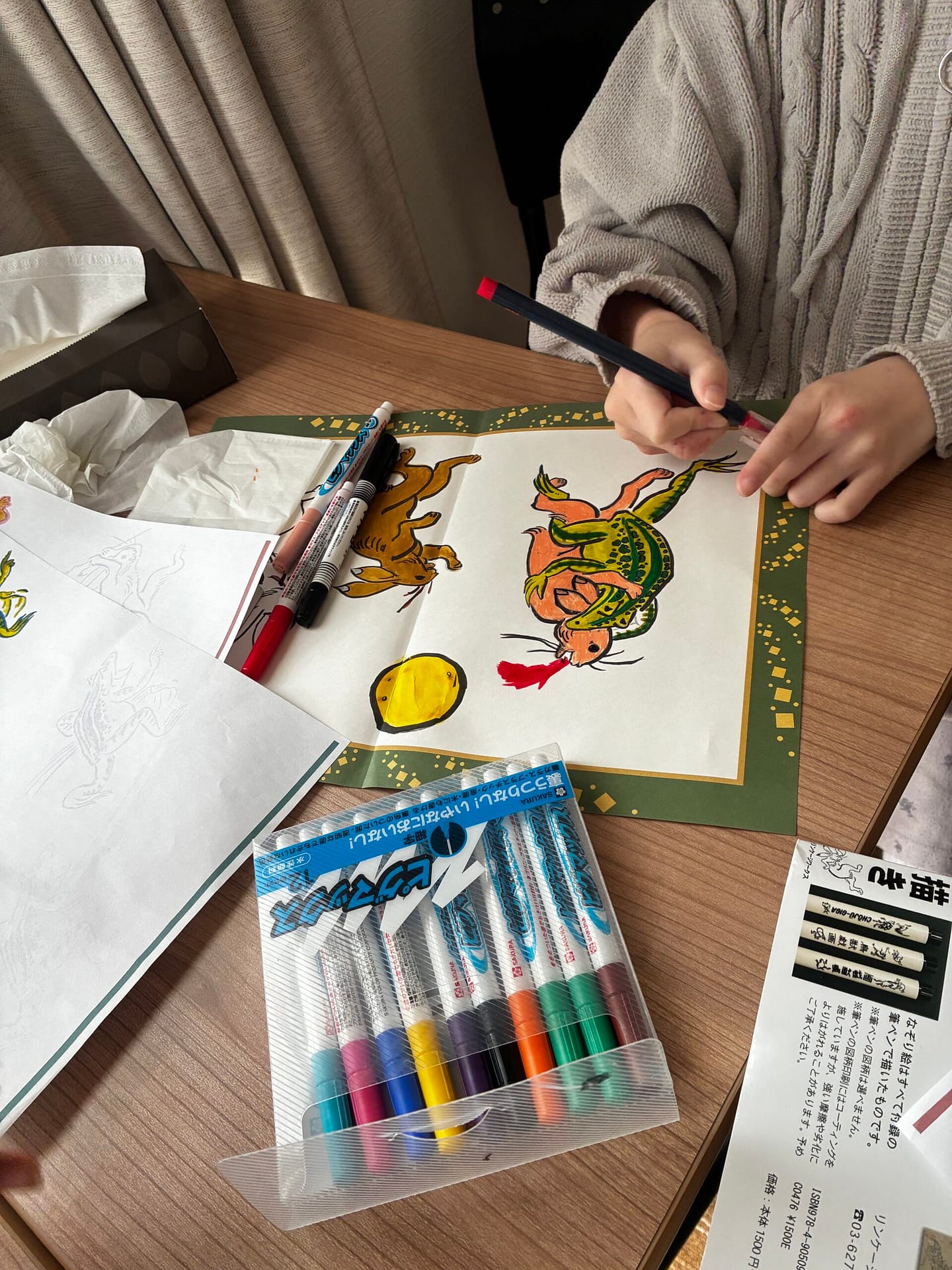 色鉛筆を使って絵を仕上げる手元