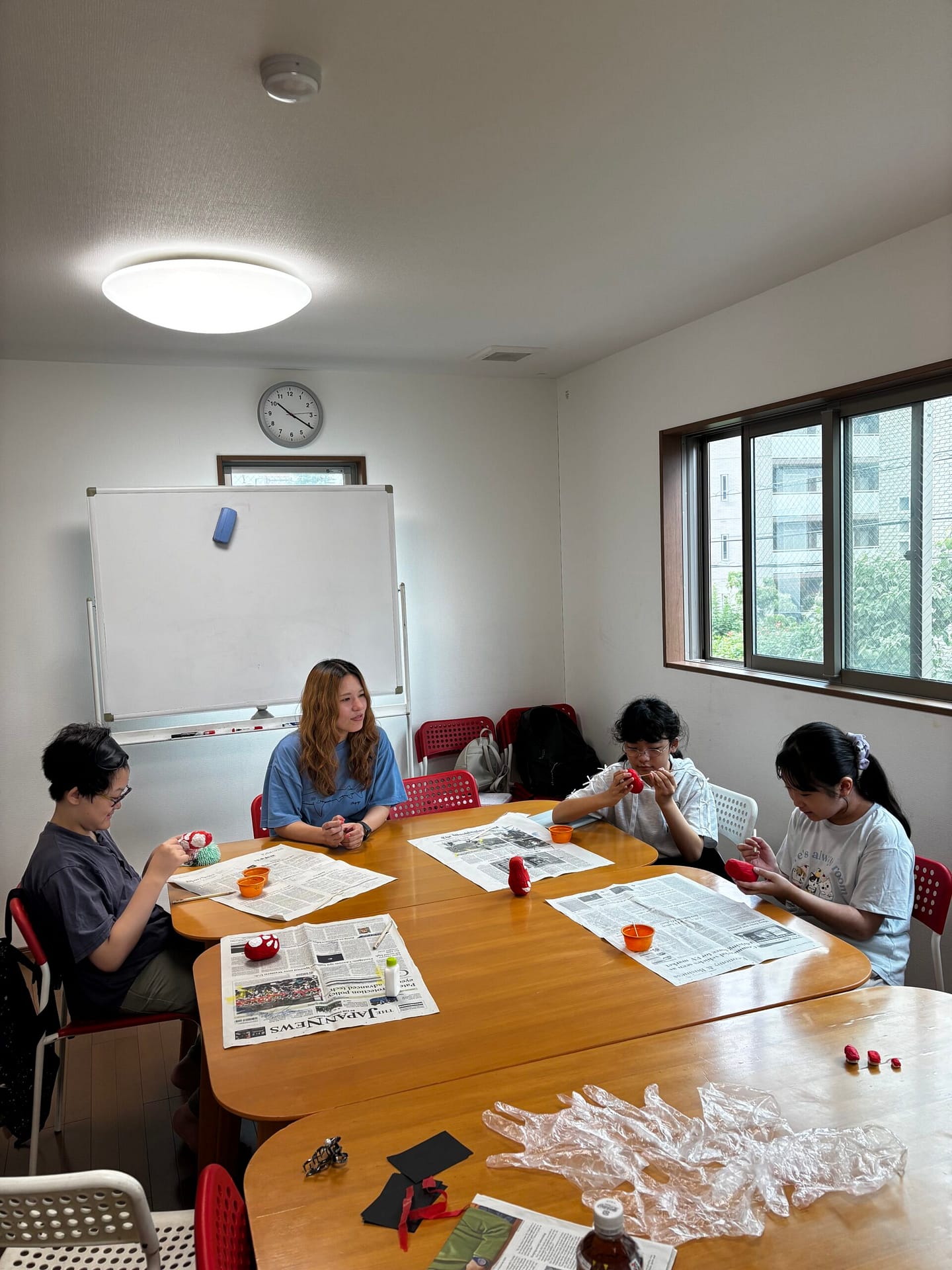 室内のテーブルを囲んで大人と子どもが一緒に活動する様子