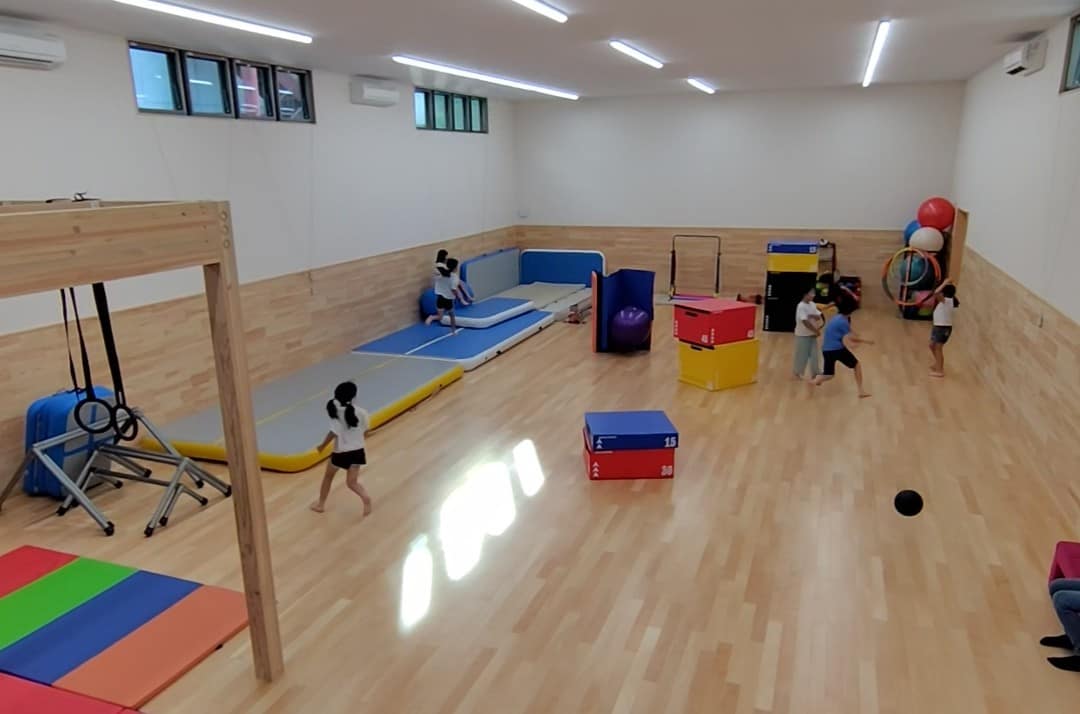 広い室内で体を動かして遊ぶ子どもたち